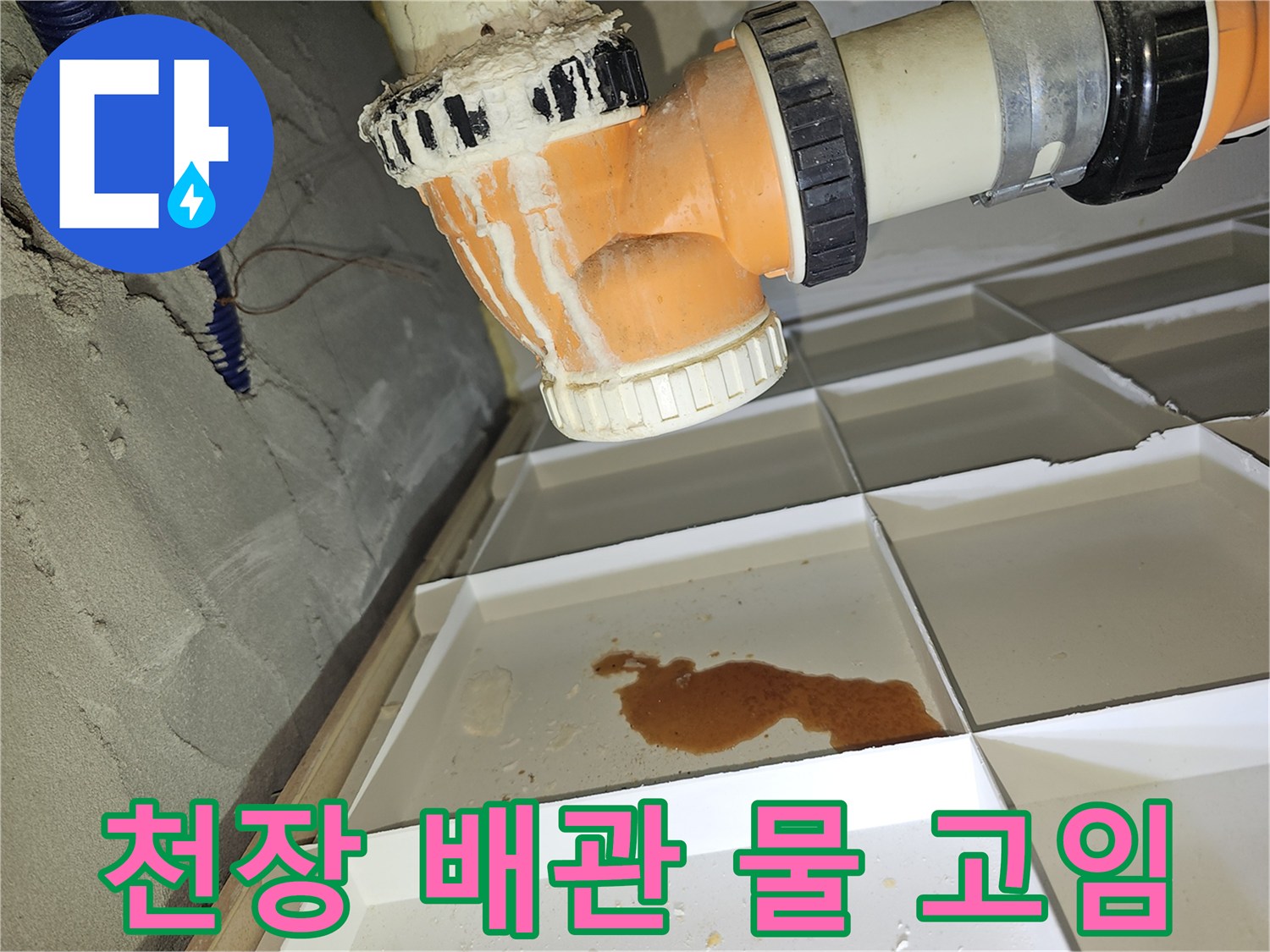 아파트 천장 점검구 내부의 오렌지색 배관과 주변에 고인 물 상태