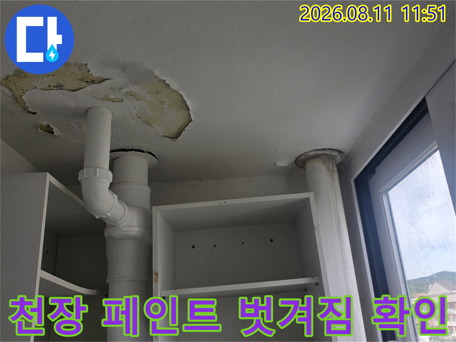 하얀 배관 주변 천장 도장이 들떠서 벗겨진 누수 흔적 부위