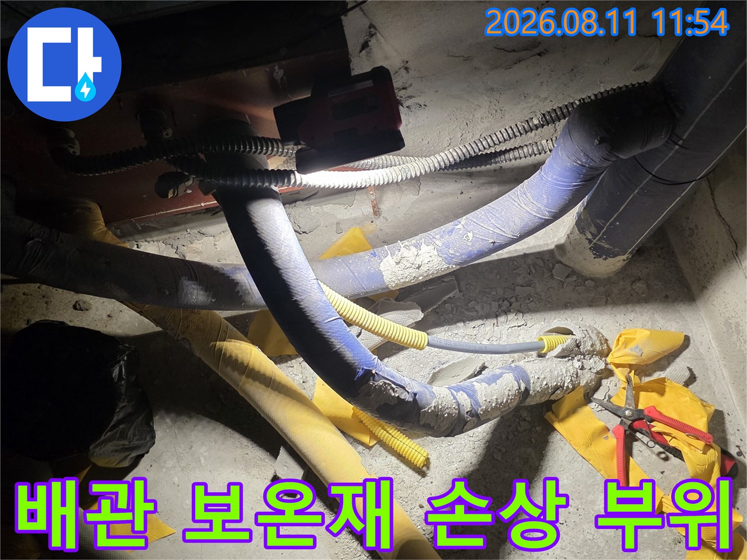 파란색과 노란색으로 감싸진 배관의 마감재가 훼손된 모습입니다.