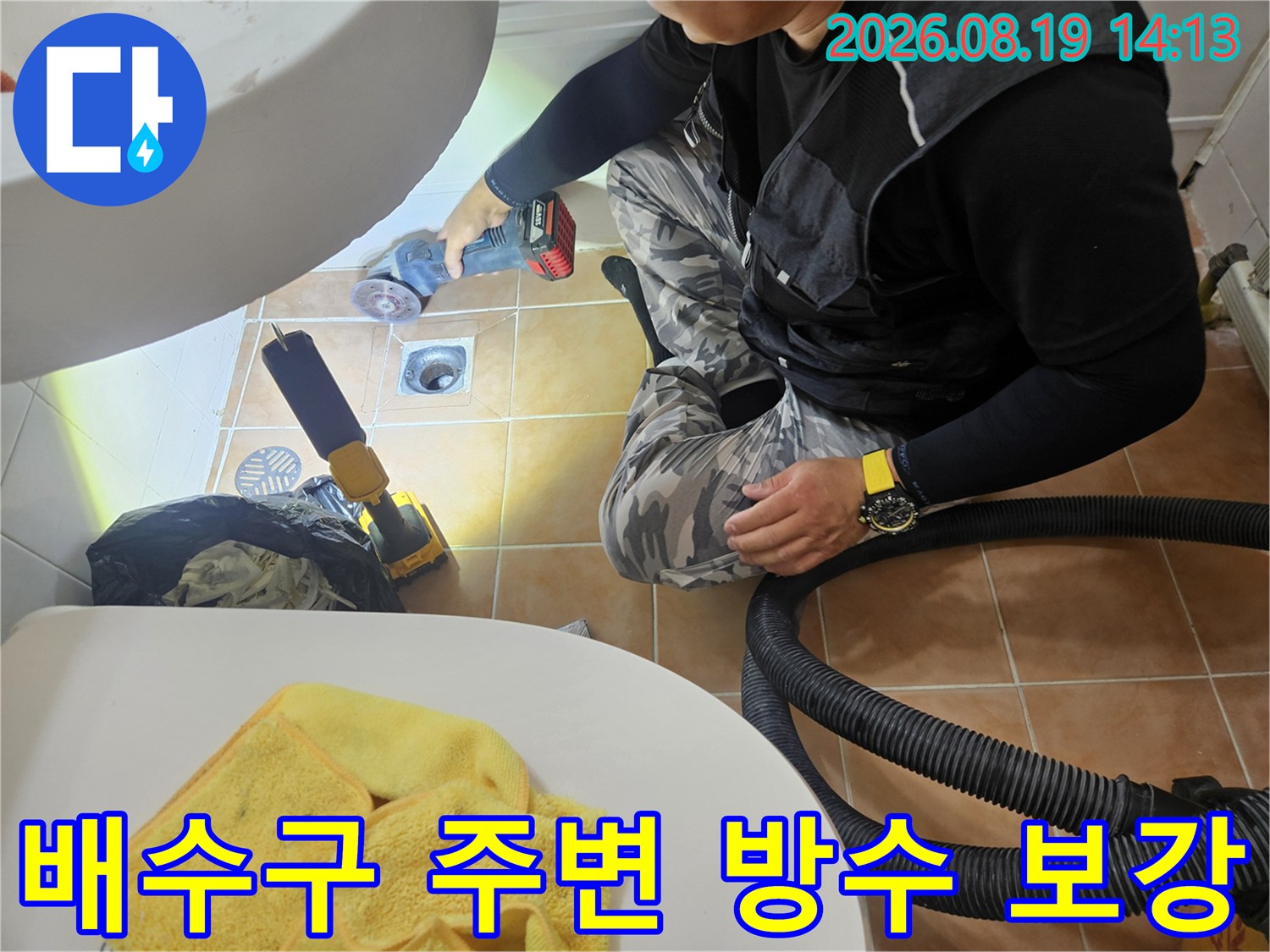 전동 공구를 사용하여 배수구 주변의 노후된 부분을 정리하고 있습니다.