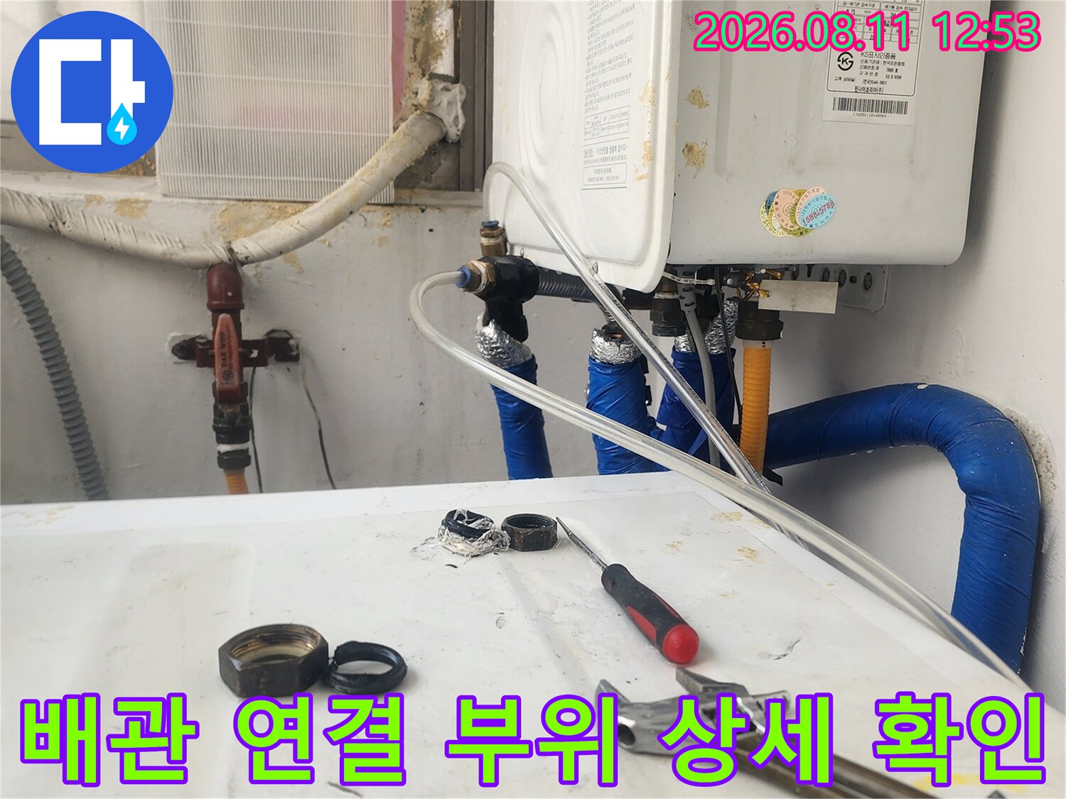 보일러 하단 밸브와 파란색 배관의 연결 상태를 촬영한 사진
