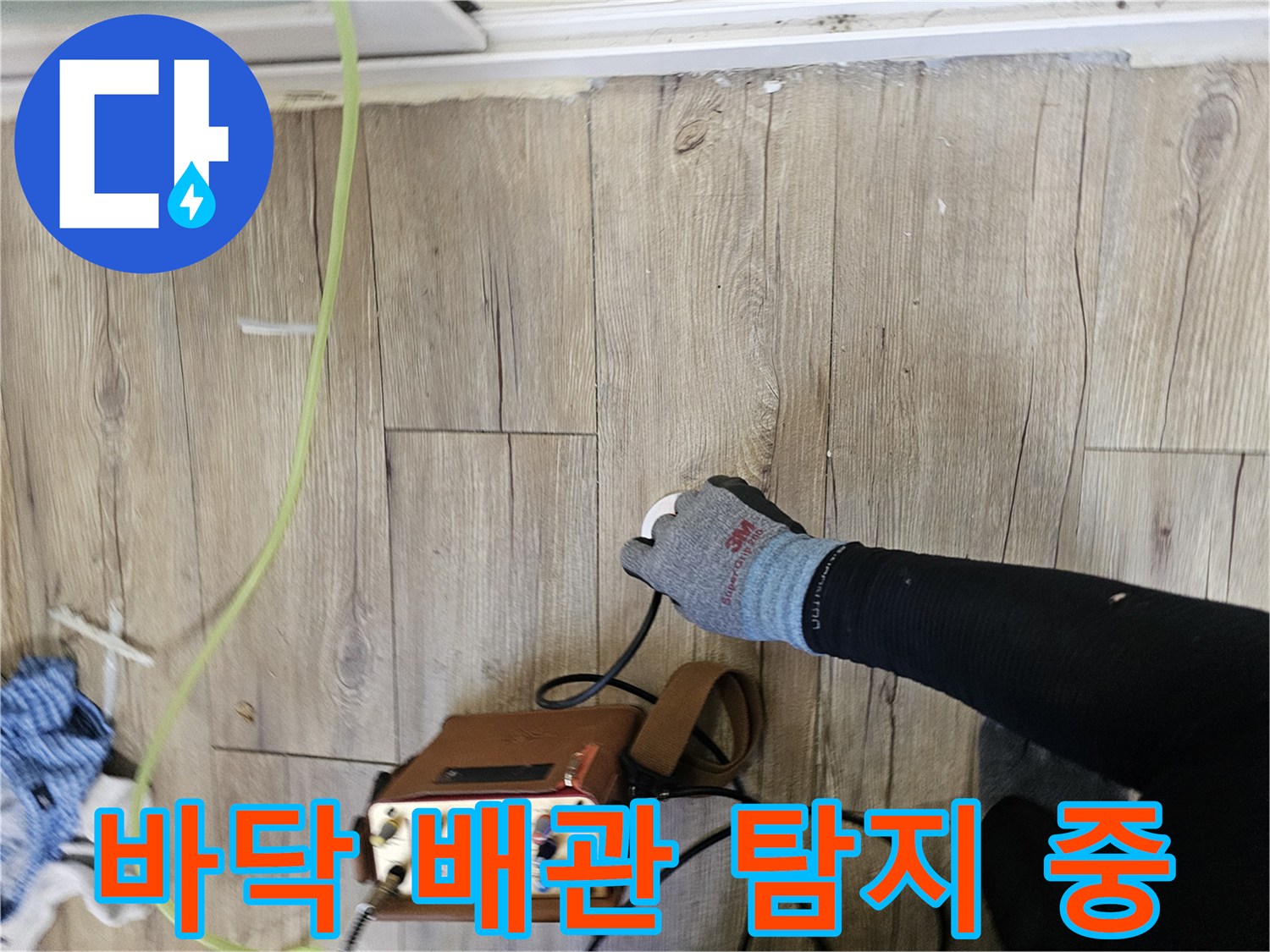 나무 바닥재 위에서 누수 탐지 장비를 사용하는 모습