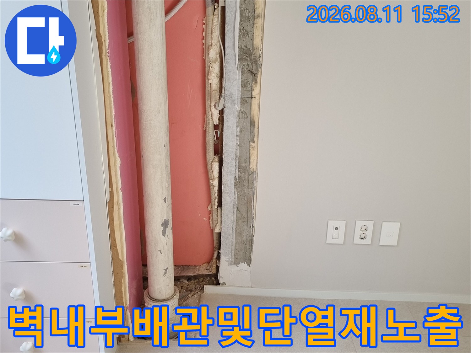 굴착된 벽면 속에 설치된 우수관 배관과 분홍색 단열재의 모습