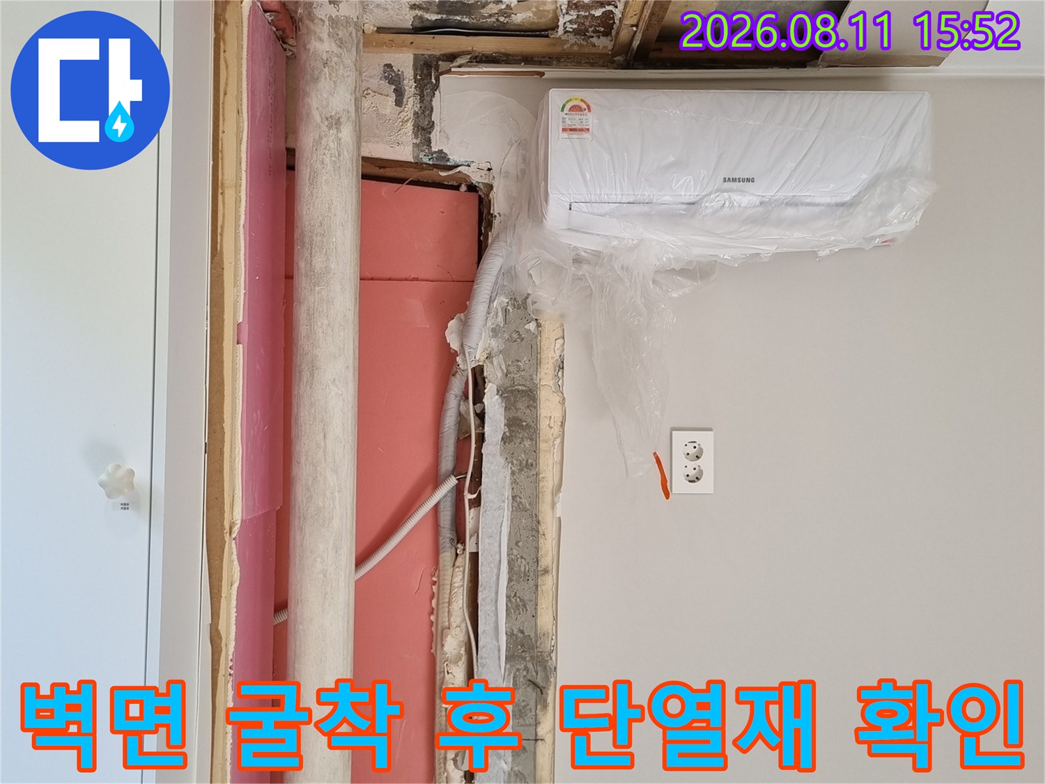 에어컨 실내기와 인접한 벽면 내부의 분홍색 단열재와 흰색 배관 사진
