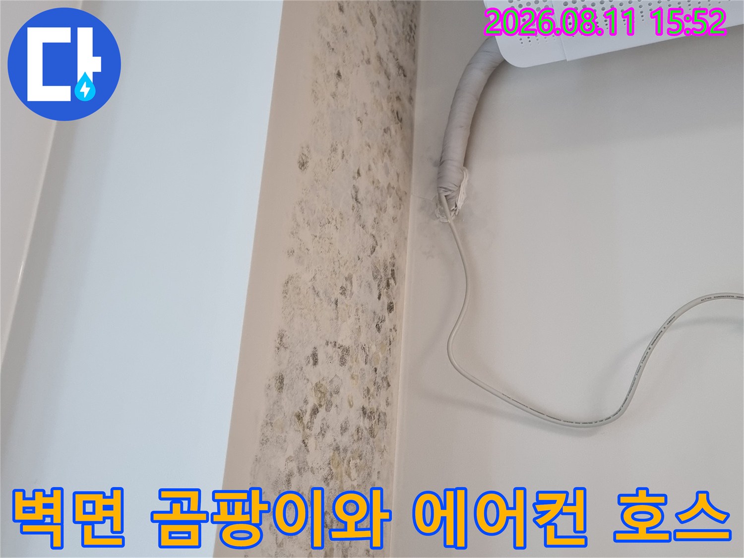 흰색 벽면에 갈색과 검은색으로 번진 누수 오염물질과 설치된 에어컨 배관