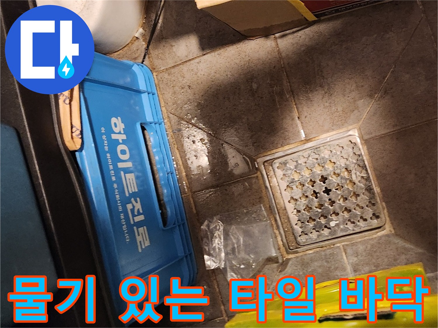 창고 내부 배수구와 주변의 젖은 타일 표면