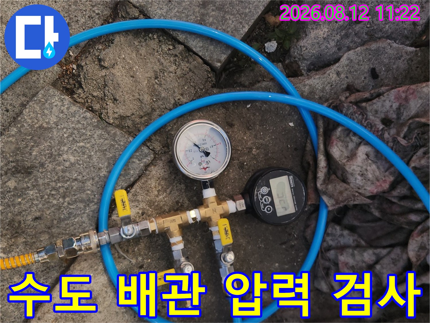 파란색 호스와 압력 게이지가 연결된 배관 부위