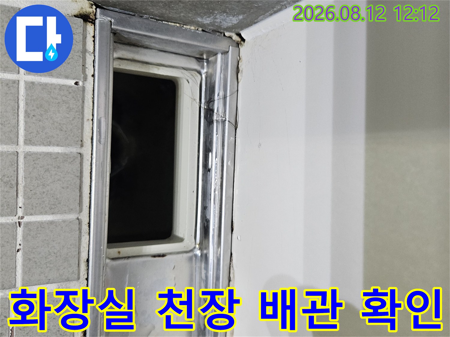 천장 점검구 안쪽의 금속 배관 받침대와 타일 경계면입니다.