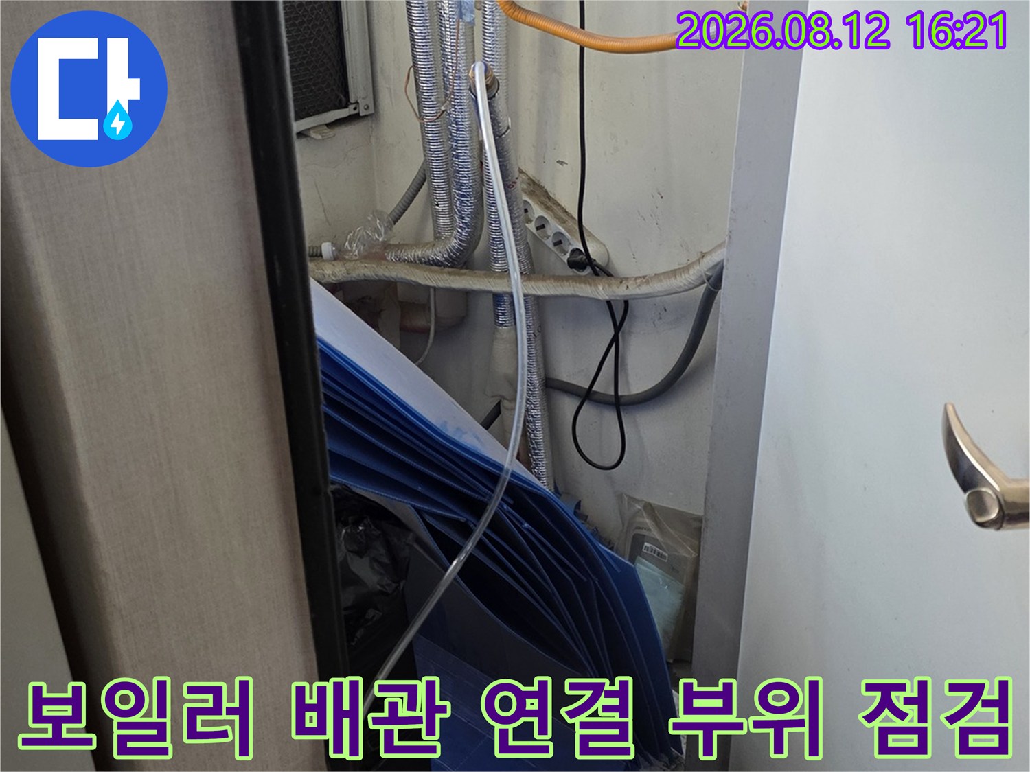 흰색 보일러 본체와 은색 단열재로 감싸진 배관-연결 부위 모습