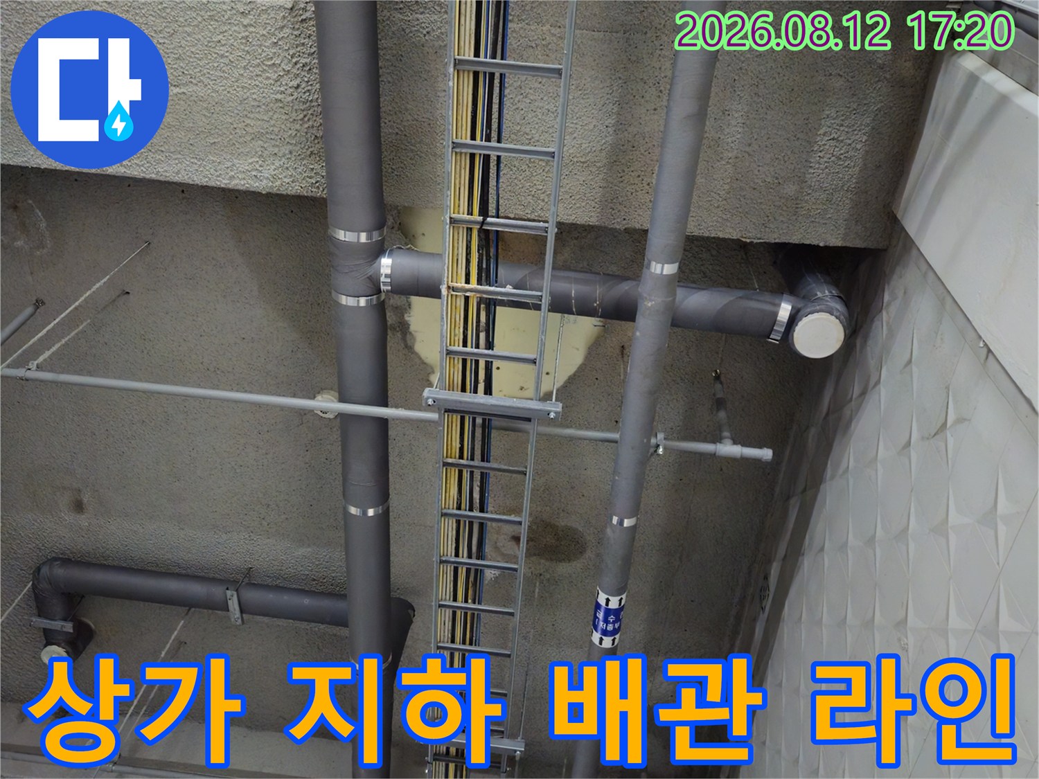 지하 주차장 천장 슬라브에 부착된 회색 배관과 전선로