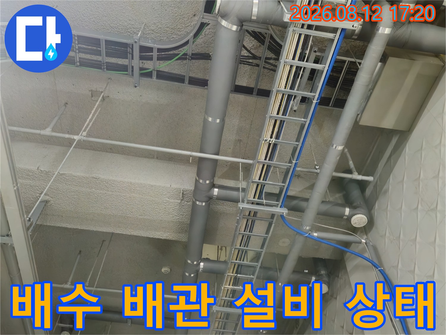 지하주차장 천장에 설치된 대형 배수관과 전선 트레이 모습입니다.