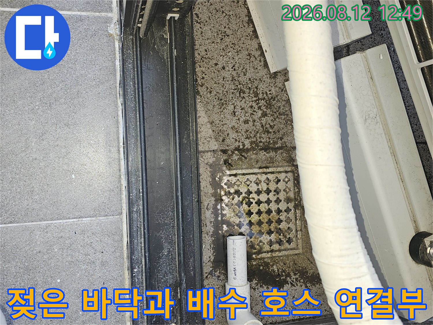 에어컨 드레인 호스 주변의 물 고임 및 오염된 타일 모습