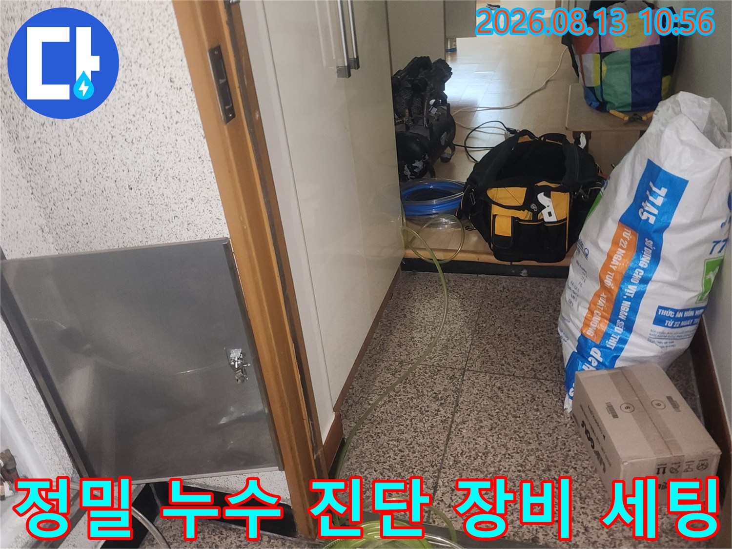 배관 연결 부위에 노란색 호스와 압력 측정기가 설치된 점검구 내부 모습