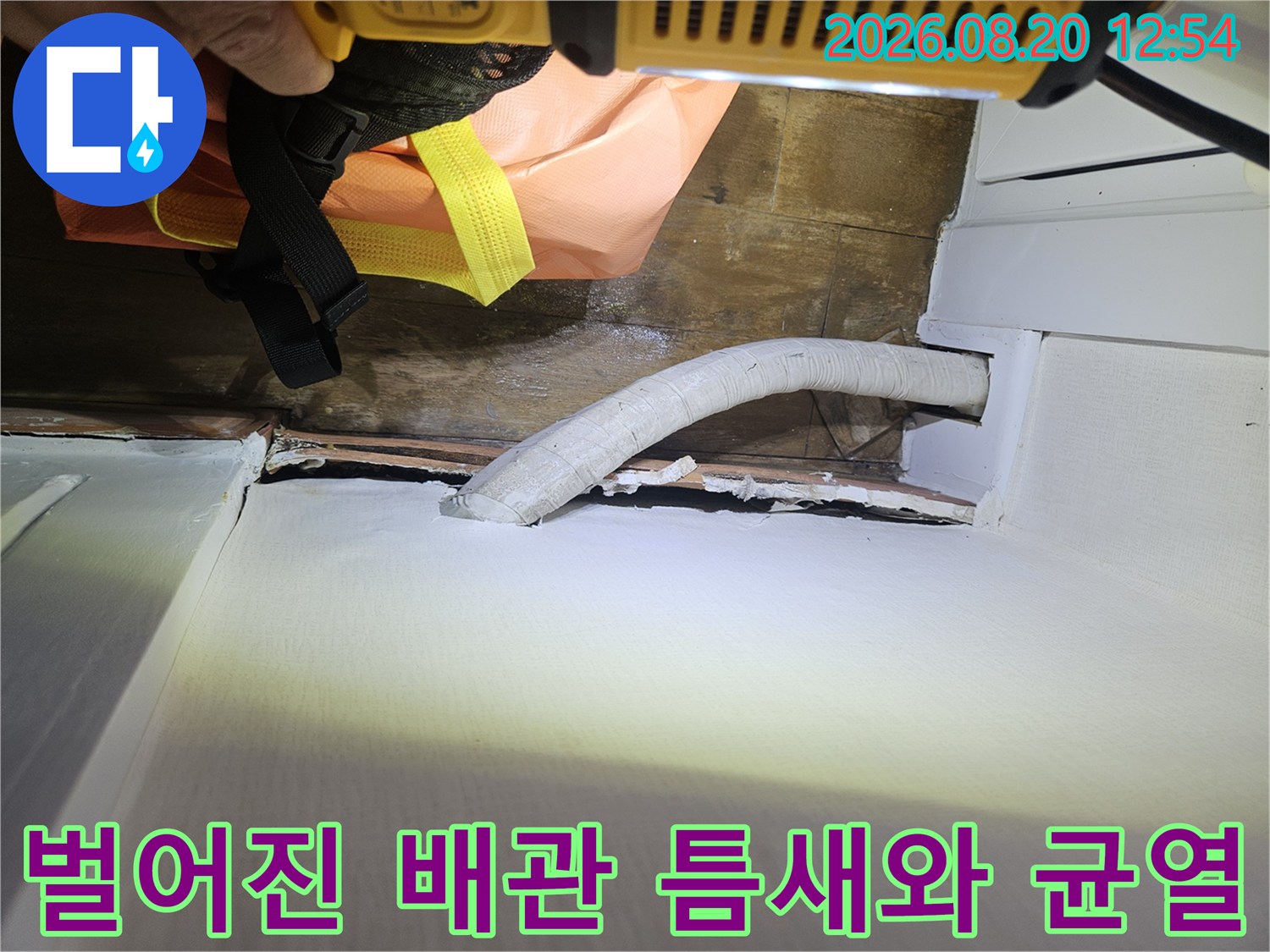 배관과 벽면 마감재 사이의 벌어진 틈을 클로즈업하여 촬영한 사진입니다.