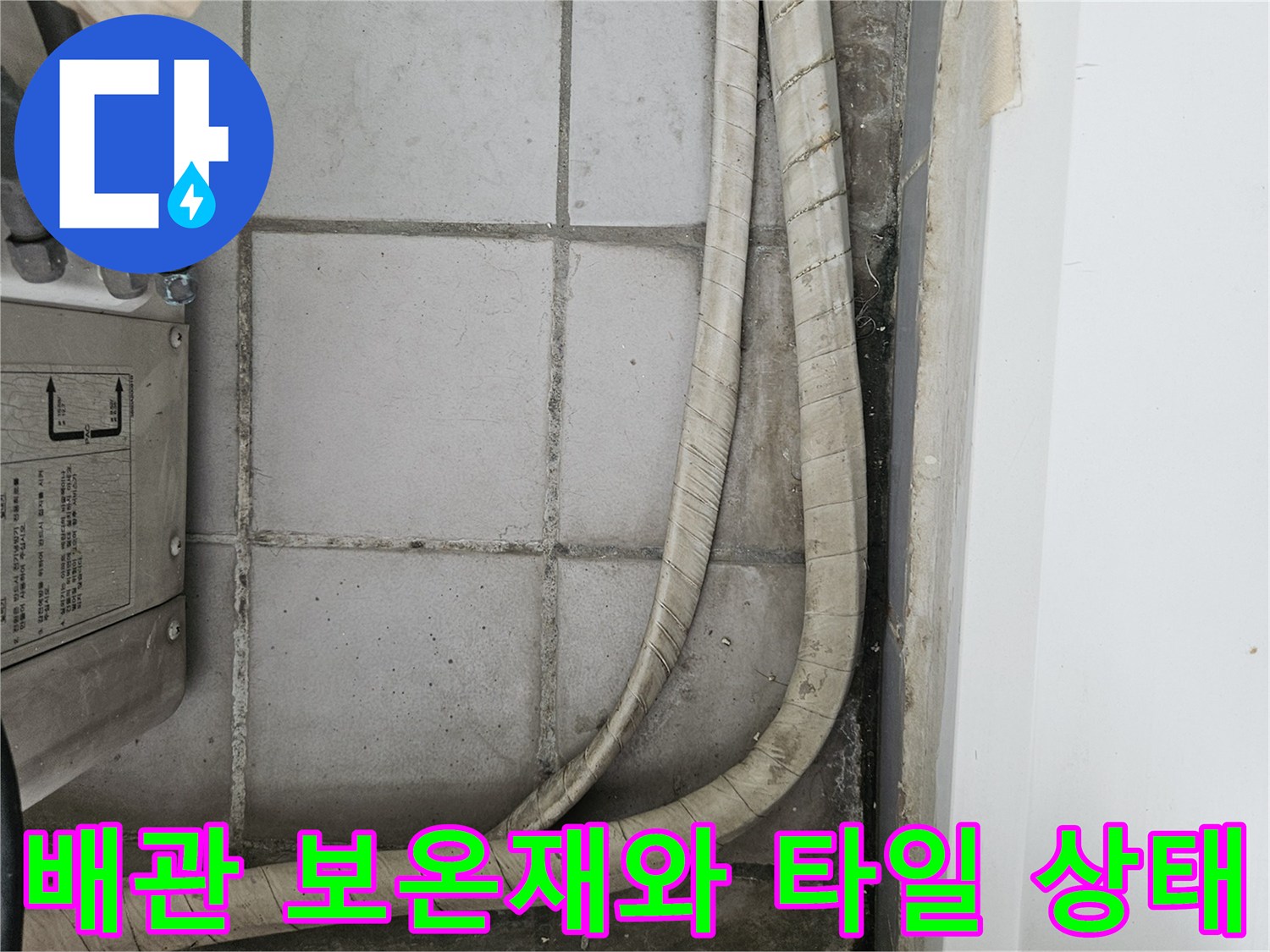 우수관 배관을 감싼 보온재와 인접한 타일 벽면의 모습
