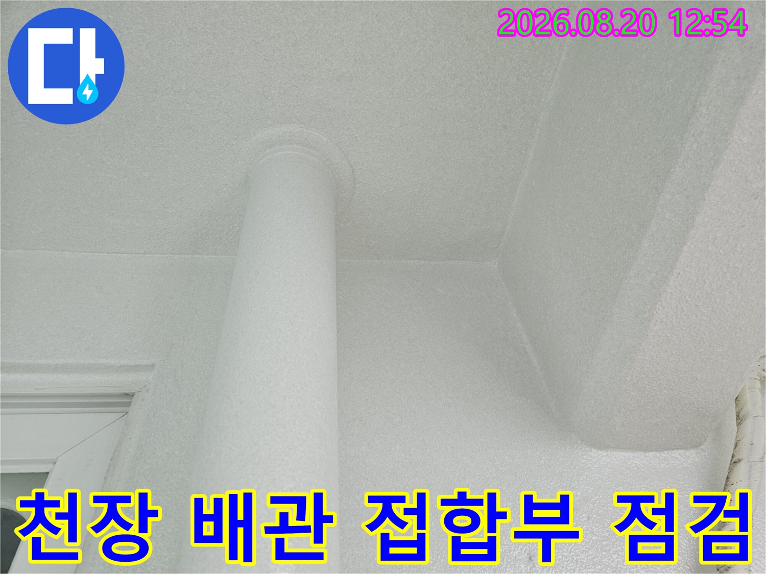 하얀색 천장 마감재와 우수관 배관의 연결 부위 근접 촬영