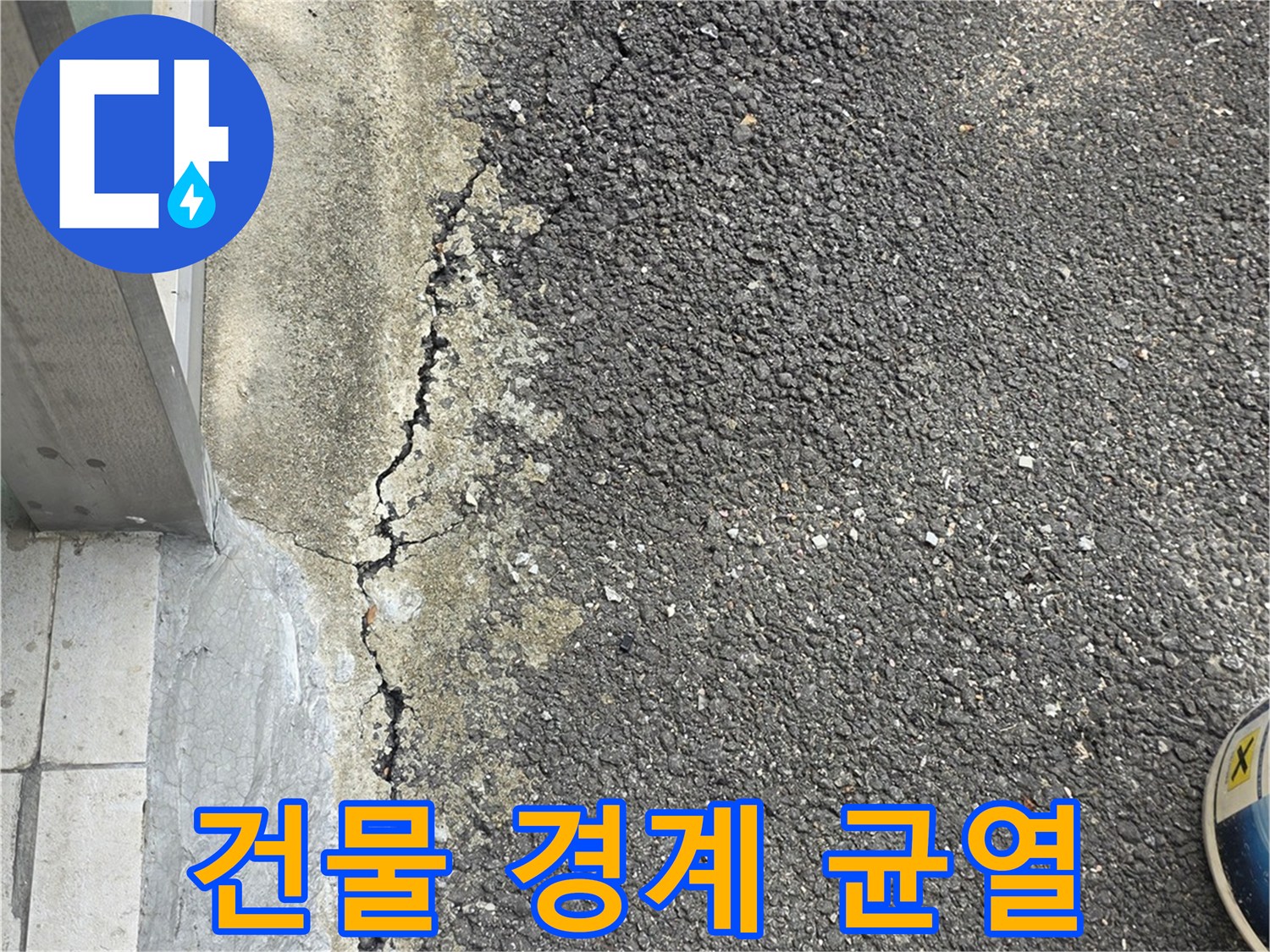 아스팔트와 건물-틈새가 벌어진 외벽 하단부 모습