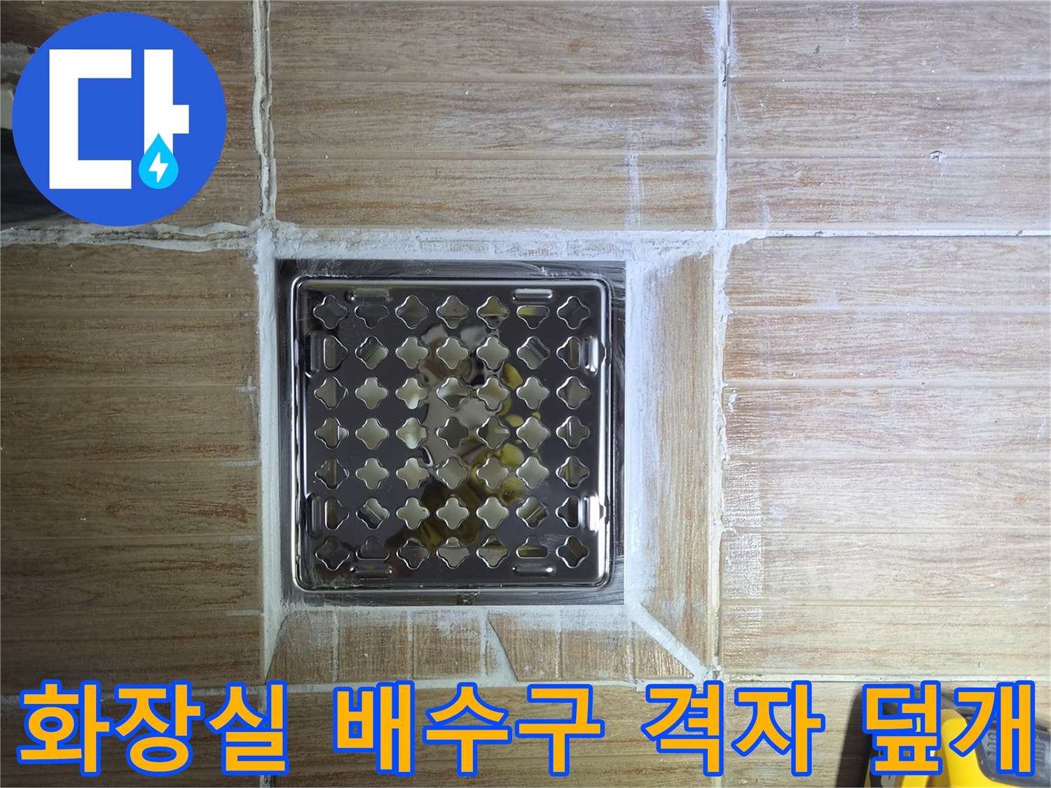 금속 재질의 배수구 덮개와 주변 타일 면