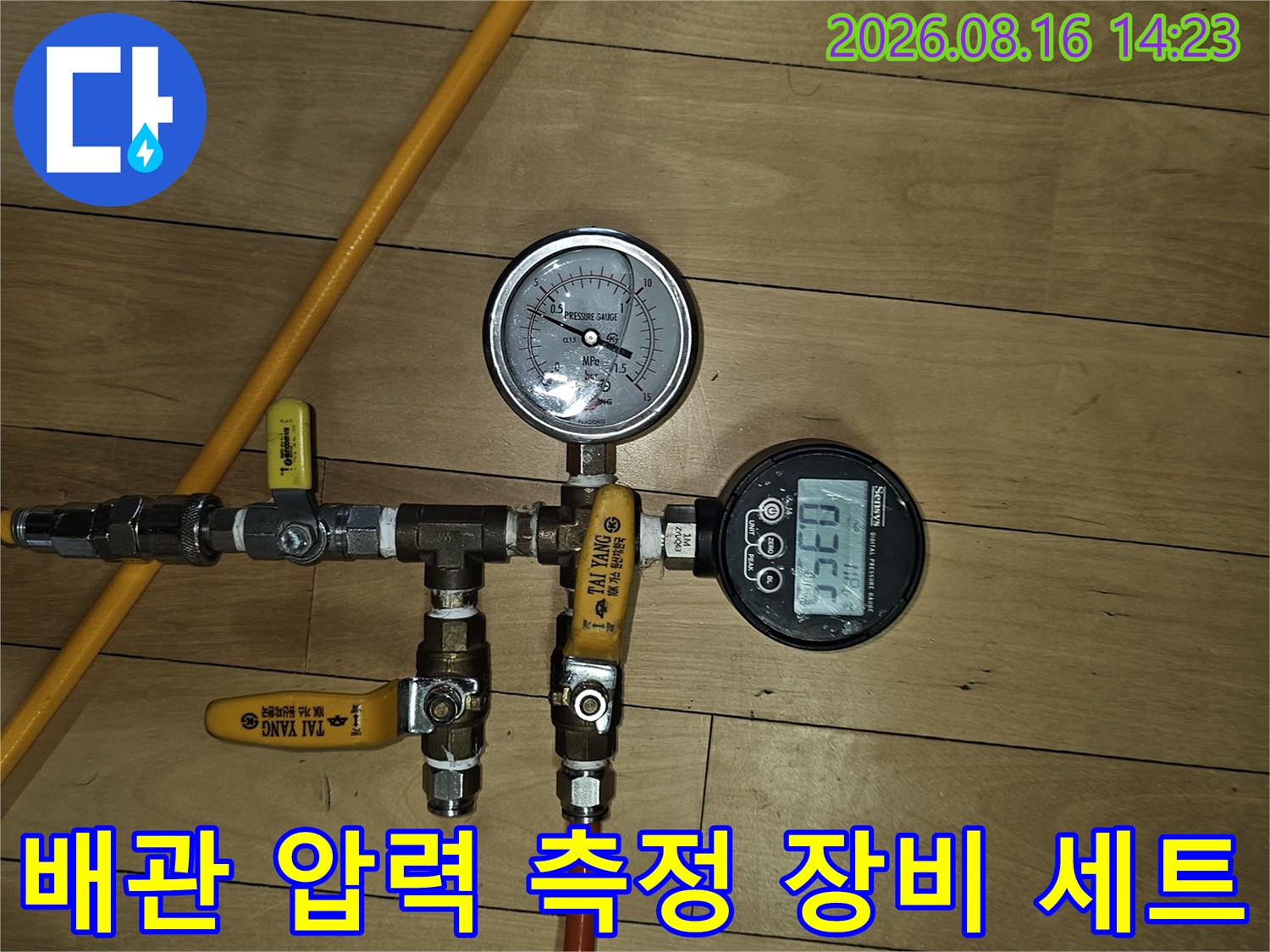 노란색 호스와 밸브가 연결된 배관 압력 측정용 장치입니다.
