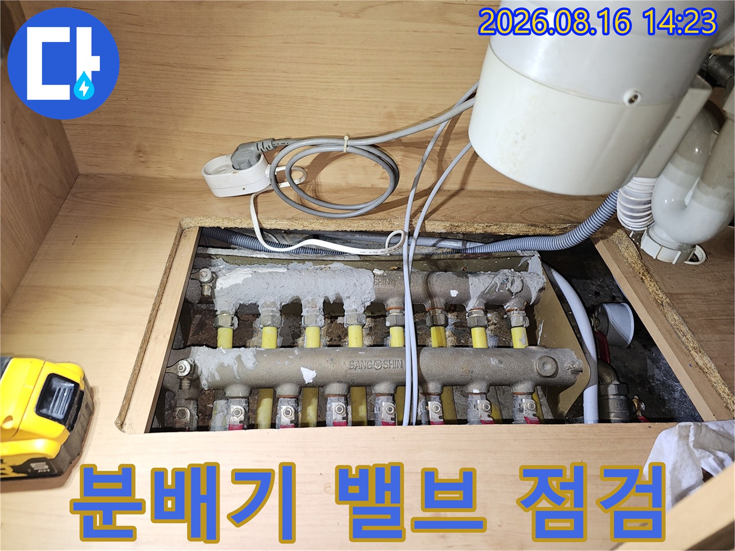싱크대 하부 공간에 노출된 보일러 분배기 밸브와 연결 배관들입니다.