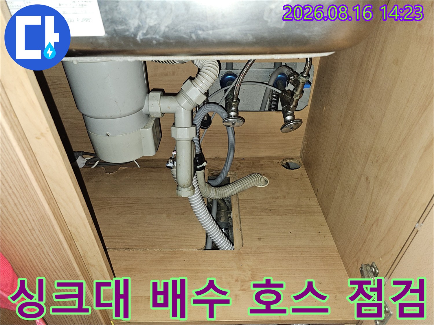싱크대 하부의 흰색 배수 관로와 연결 부위 상세 사진