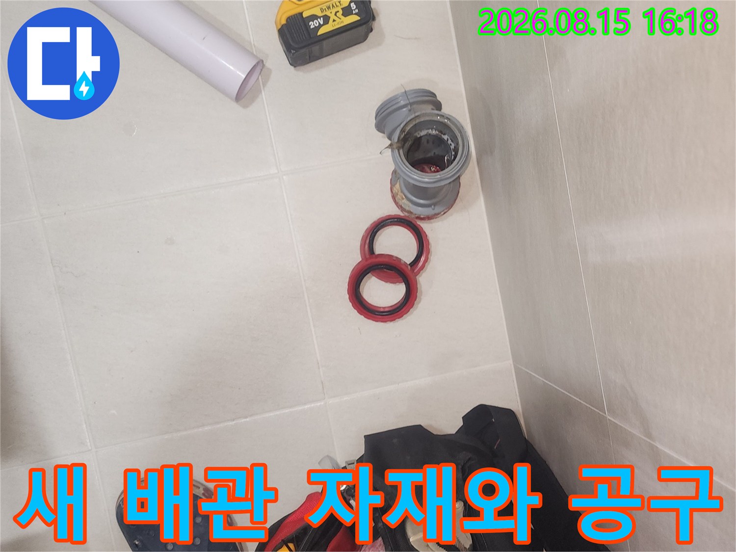 전동 드릴과 교체용 배관 부속이 놓여 있는 작업 현장