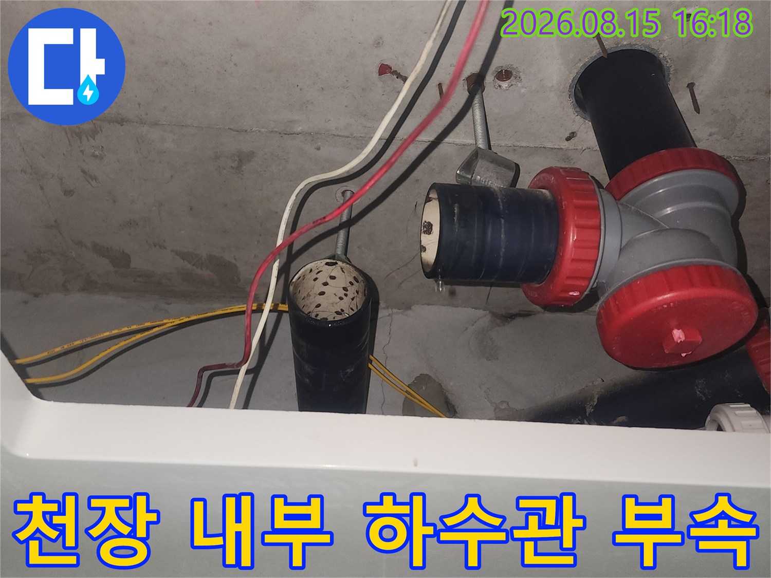 화장실 천장 안쪽의 붉은색 연결 부속과 주변 배관 구조