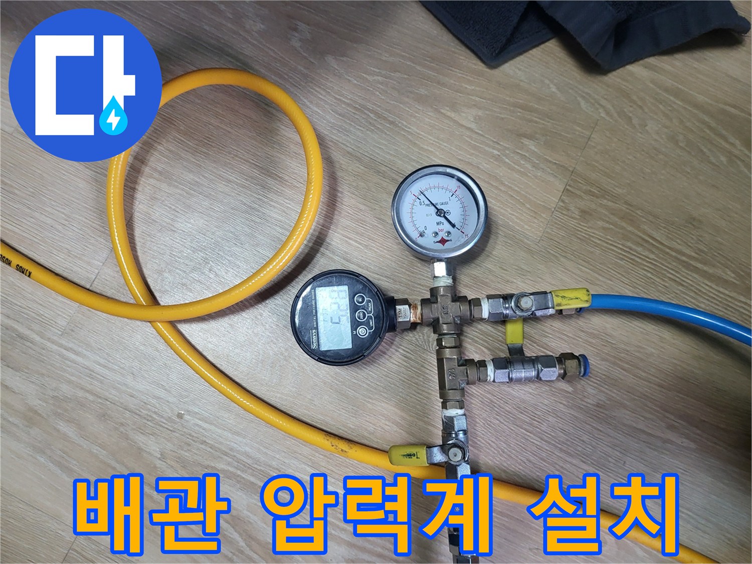 노란색 호스가 연결된 배관 분기점에 설치된 압력 측정 장비
