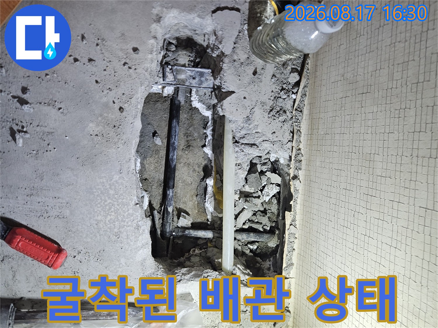 바닥을 파낸 후 드러난 배관과 주변 흙 및 콘크리트 모습