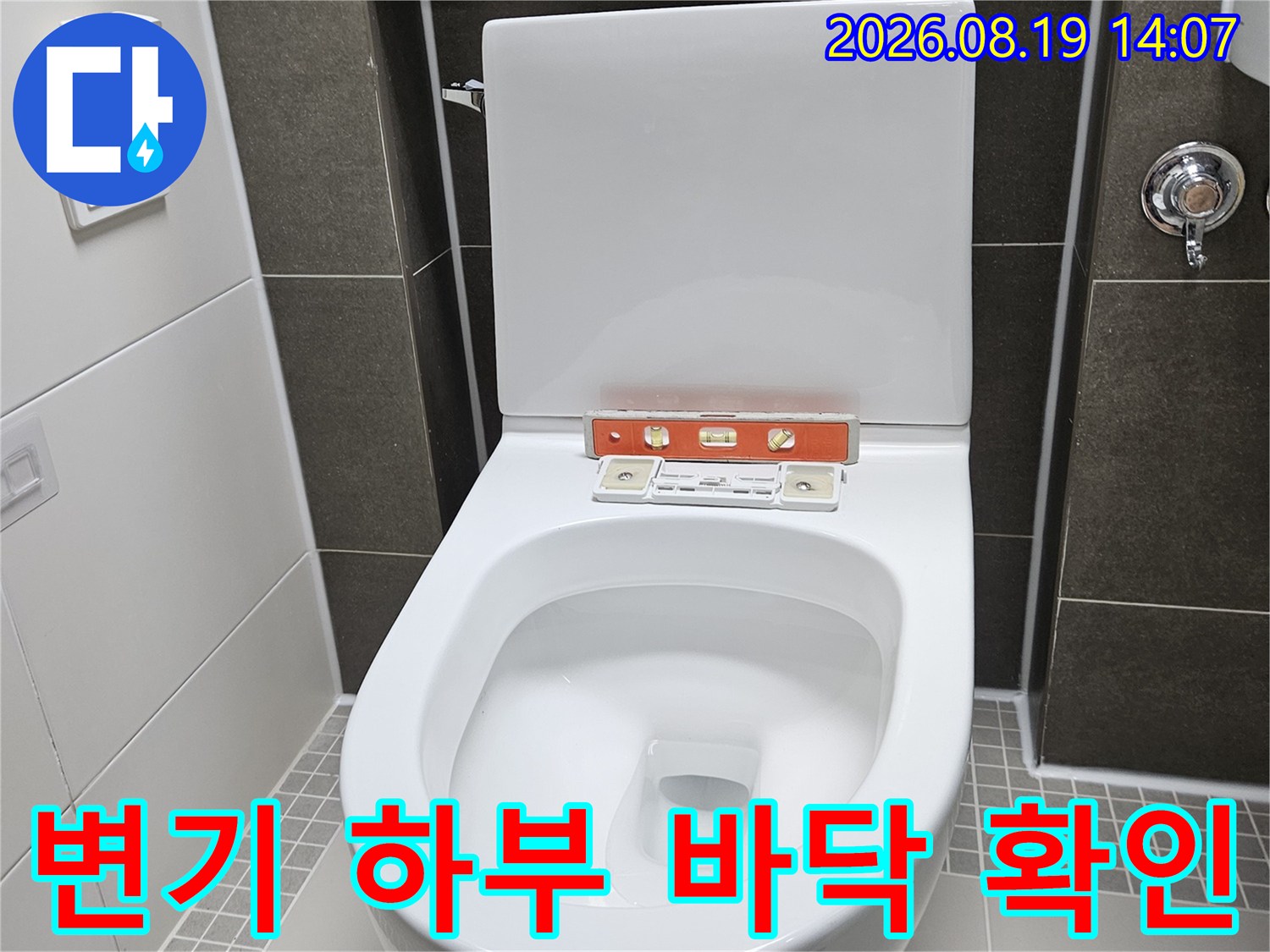 탈거된 변기 뒤쪽의 타일과 배관 연결 부위 근접 촬영