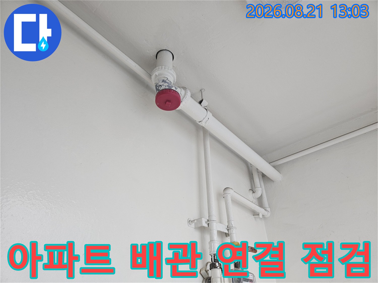 싱크대 하부의 흰색 배관과 밸브가 설치된 모습입니다.