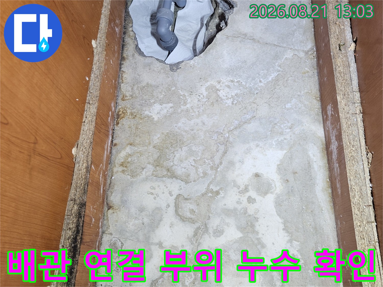 싱크대 하부장 내부의 젖은 벽체와 노출된 배부 배관