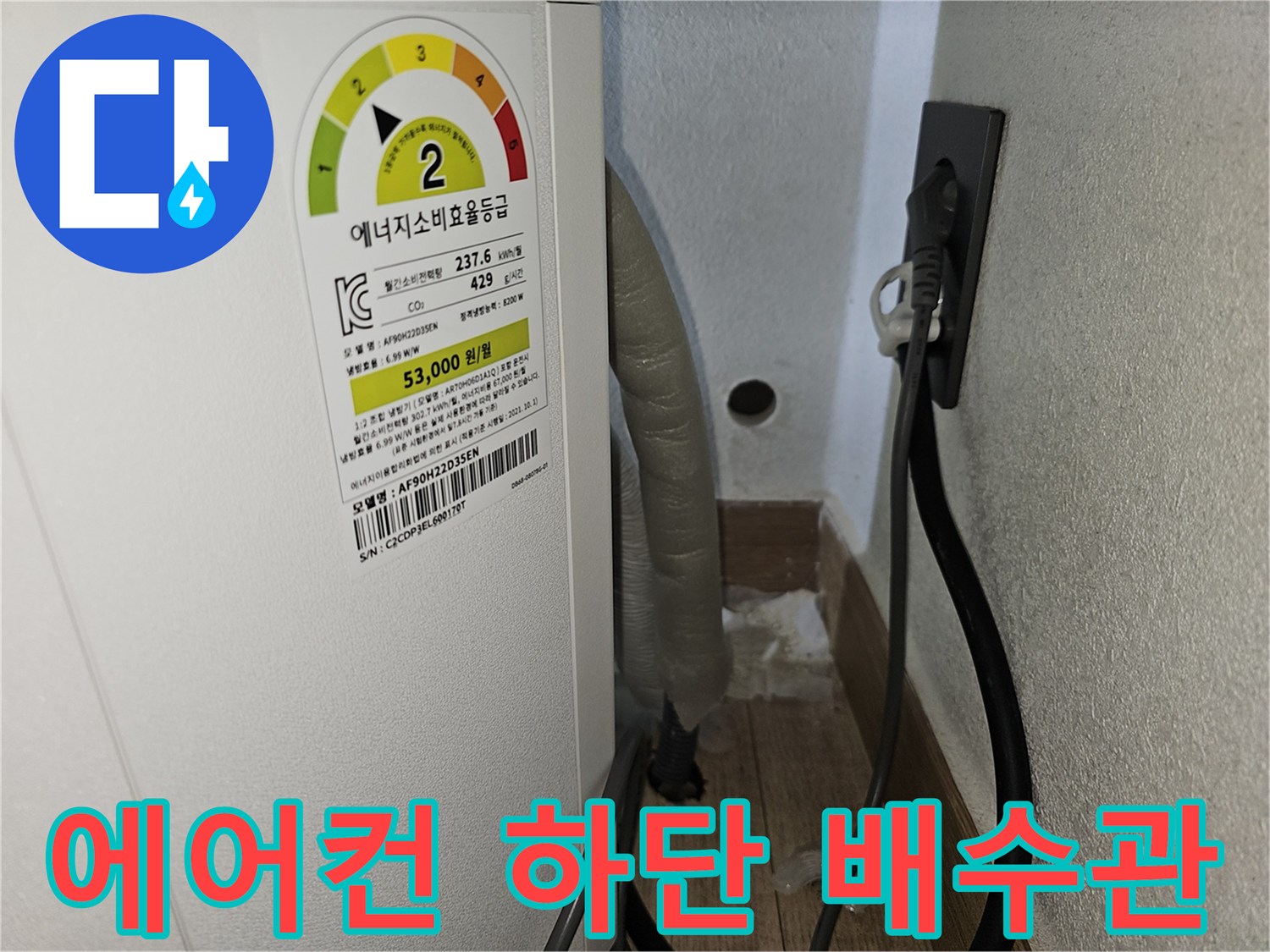 벽면 콘센트와 연결된 에어컨 드레인 호스의 근접 촬영