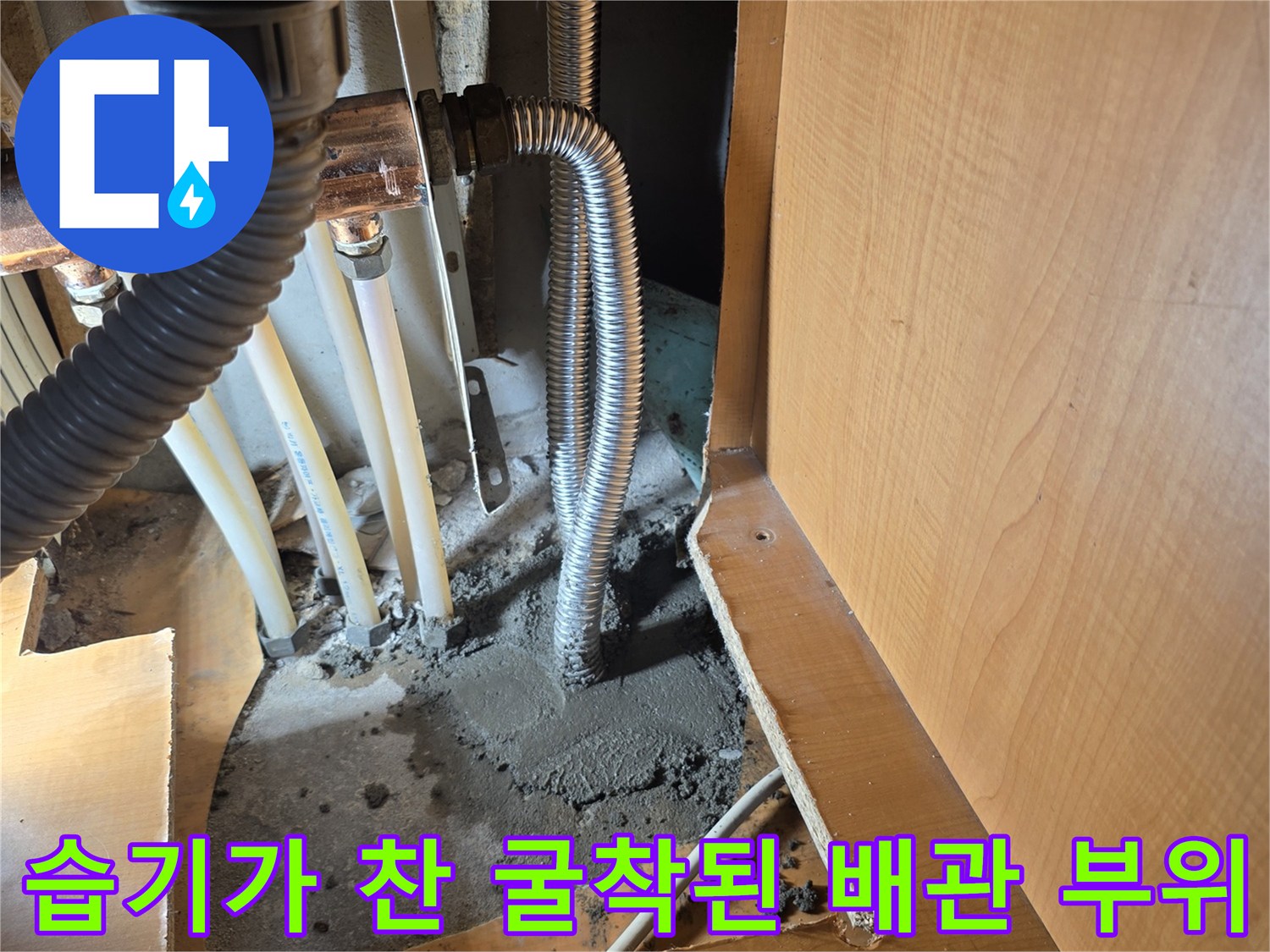 싱크대 아래 젖어 있는 배관과 흙의 모습