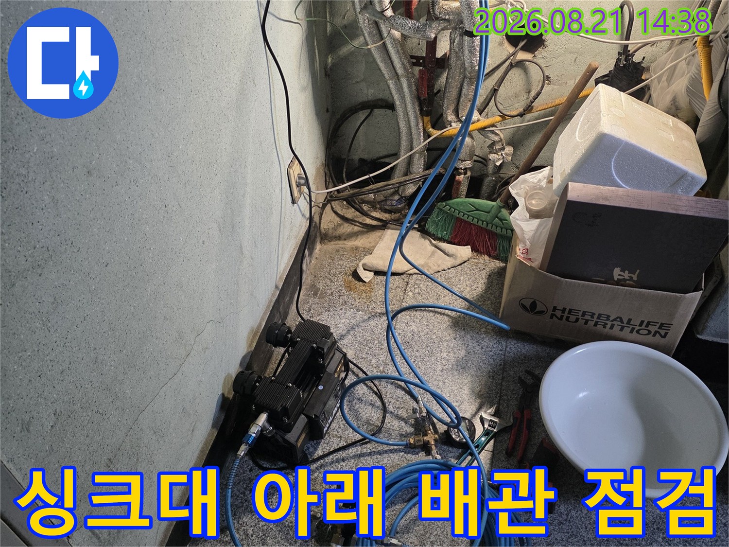 싱크대 하단 배관과 누수 탐지를 위한 장비가 설치된 모습입니다.