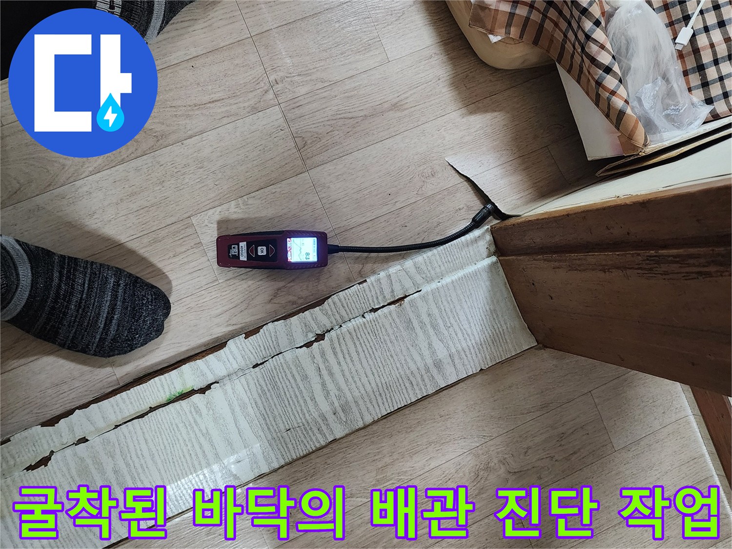 길게 파헤쳐진 바닥 틈새 사이로 탐지 장비를 투입하여 점검하는 장면