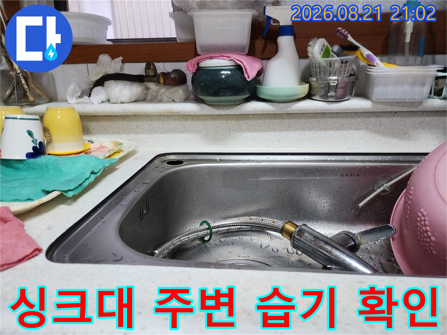 싱크대 볼의 물기와 수전 헤드를 근접하게 촬영한 이미지입니다.