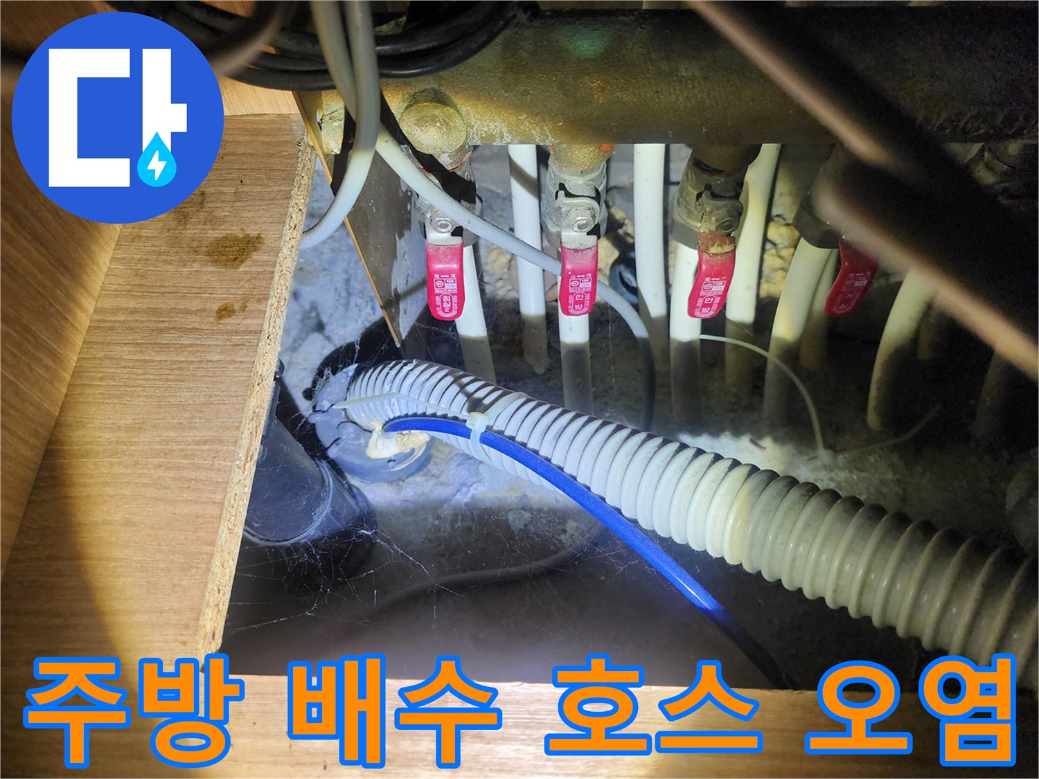 싱크대 밑 배수관 연결 부위의 젖은 흔적과 이물질
