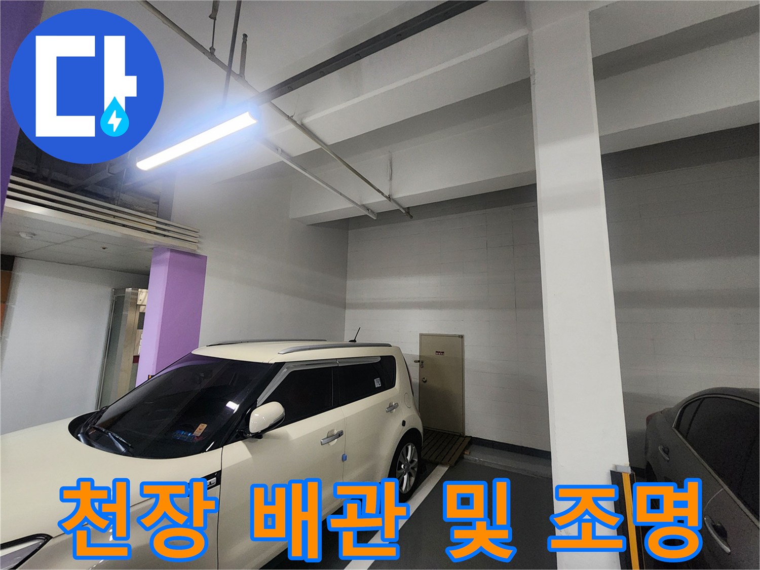 지하주차장 천장의 형광등과 노출된 배관 라인