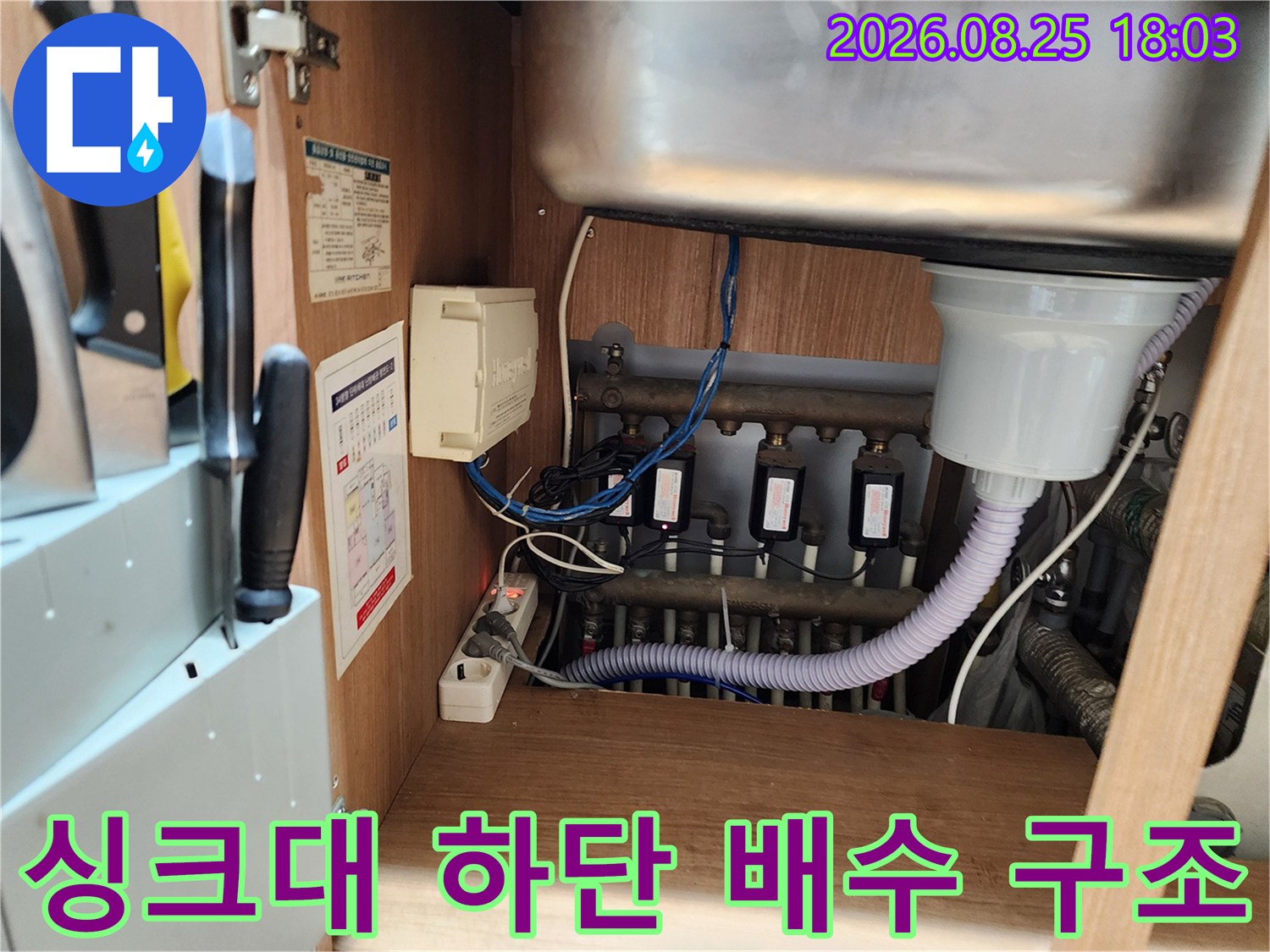 싱크대 밑 배수 호스와 연결 부위의 복잡한 배관 상태를 보여줍니다.