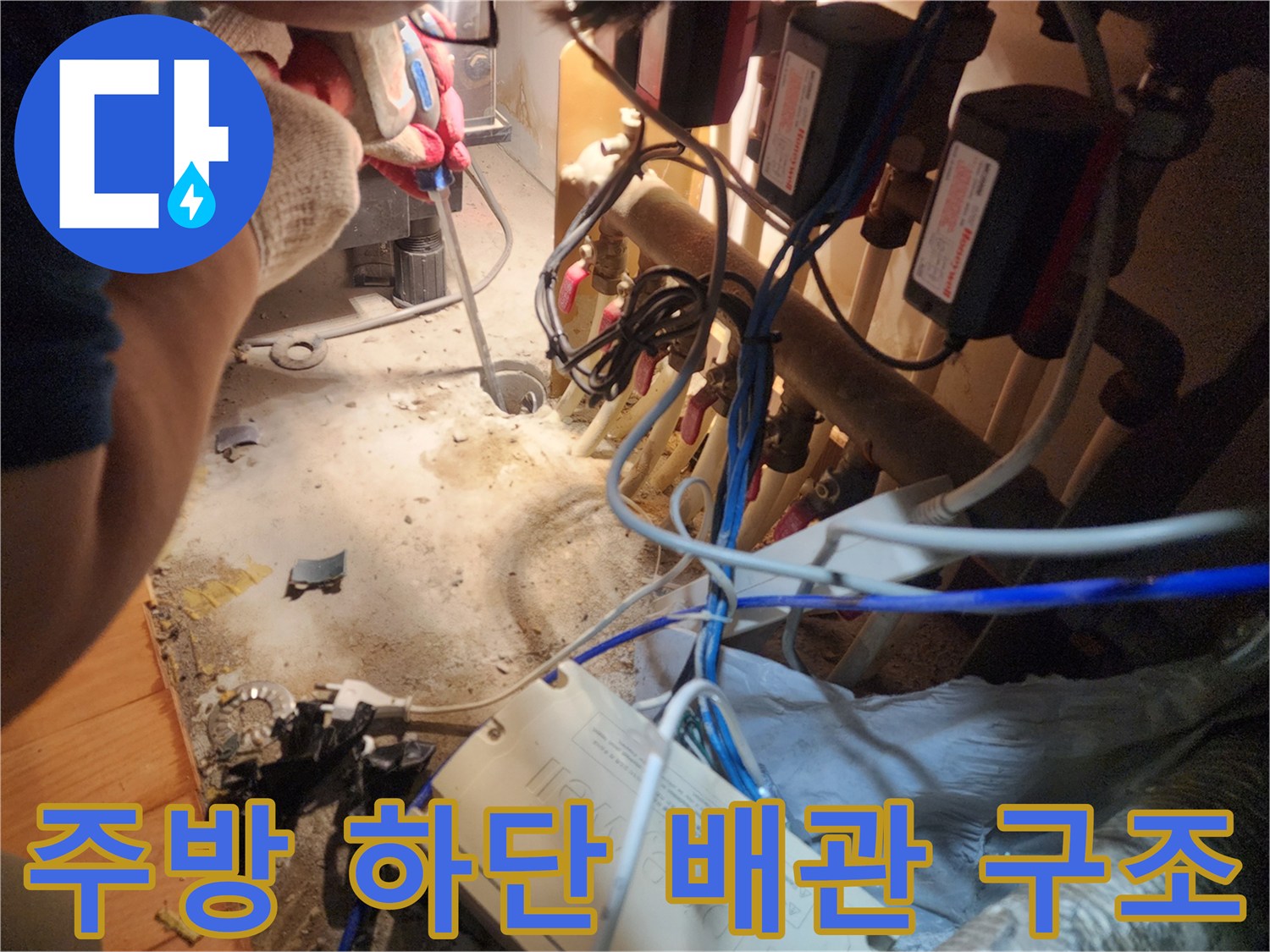 싱크대 밑 복잡한 밸브 장치-배관 역류 확인을 위해 점검 중인 하부장 내부입니다.
