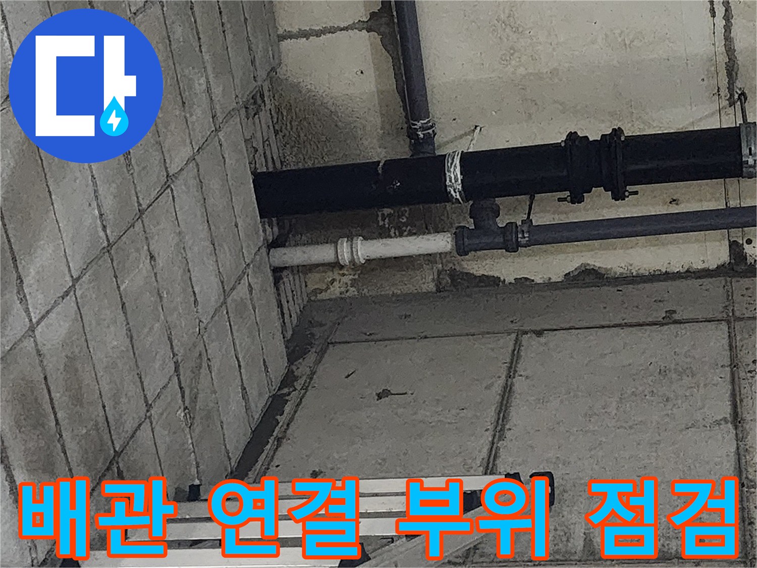 싱크대 하단 타일 벽면의 배수 배관 구조물 모습