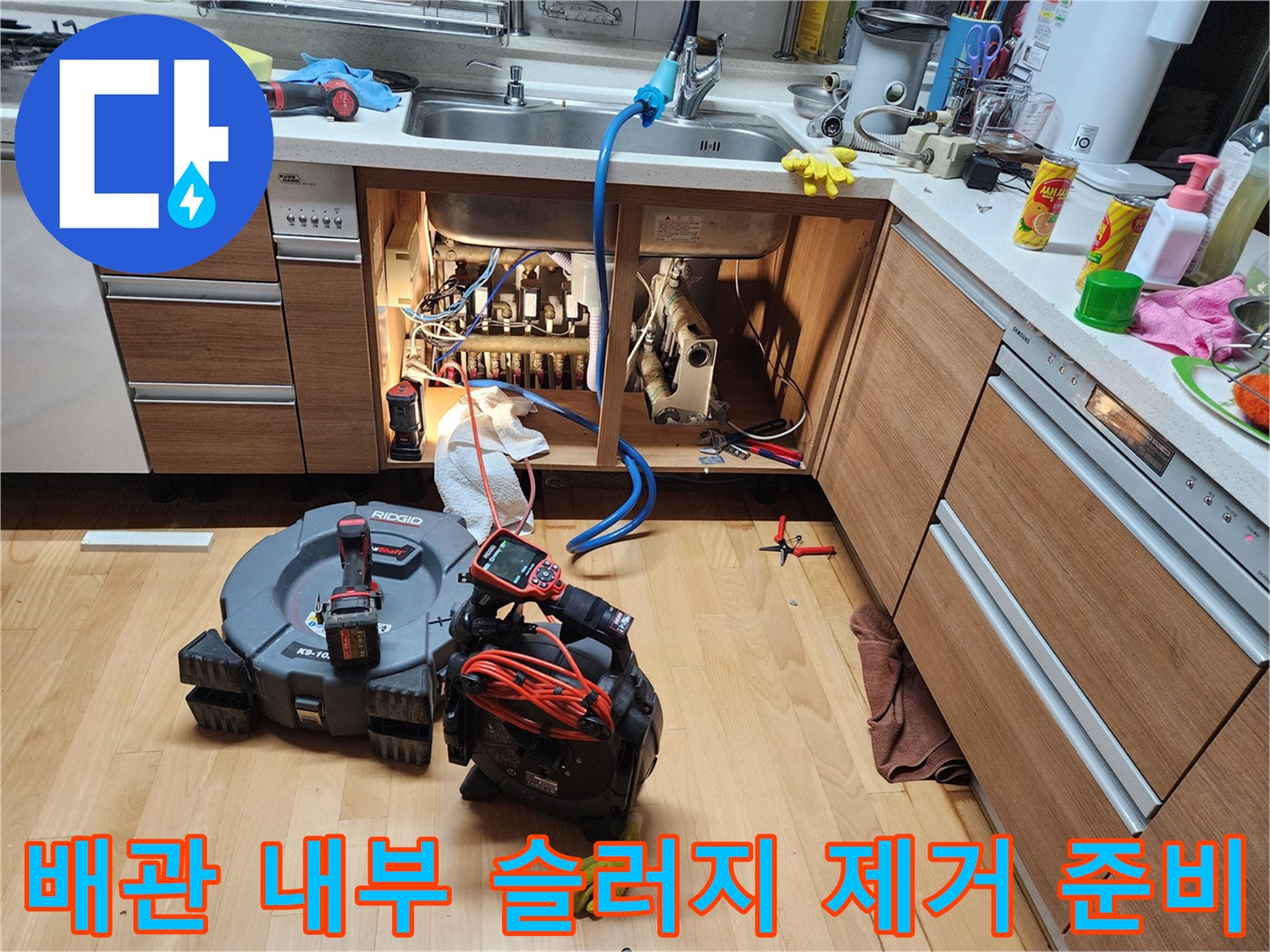싱크대 하부 배수관 주변에 배치된 배관 세척용 장비와 내시경