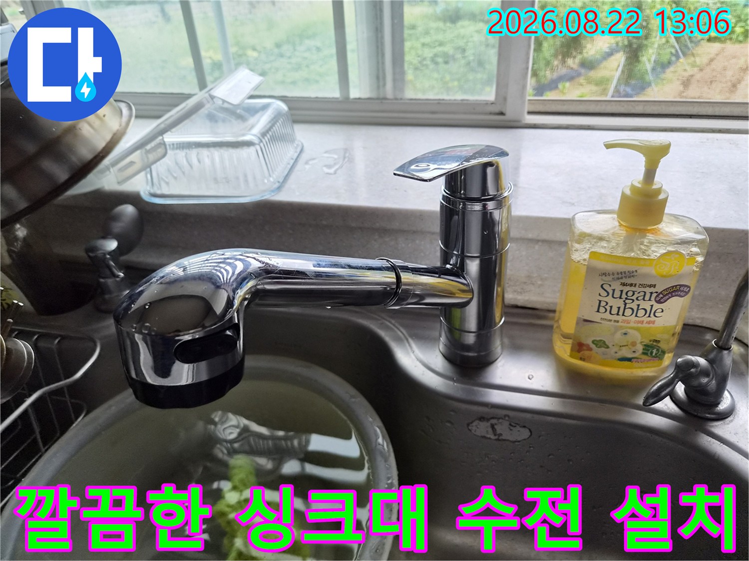 싱크대 볼 옆에 새롭게 설치된 크롬 재질의 수전 사진입니다.