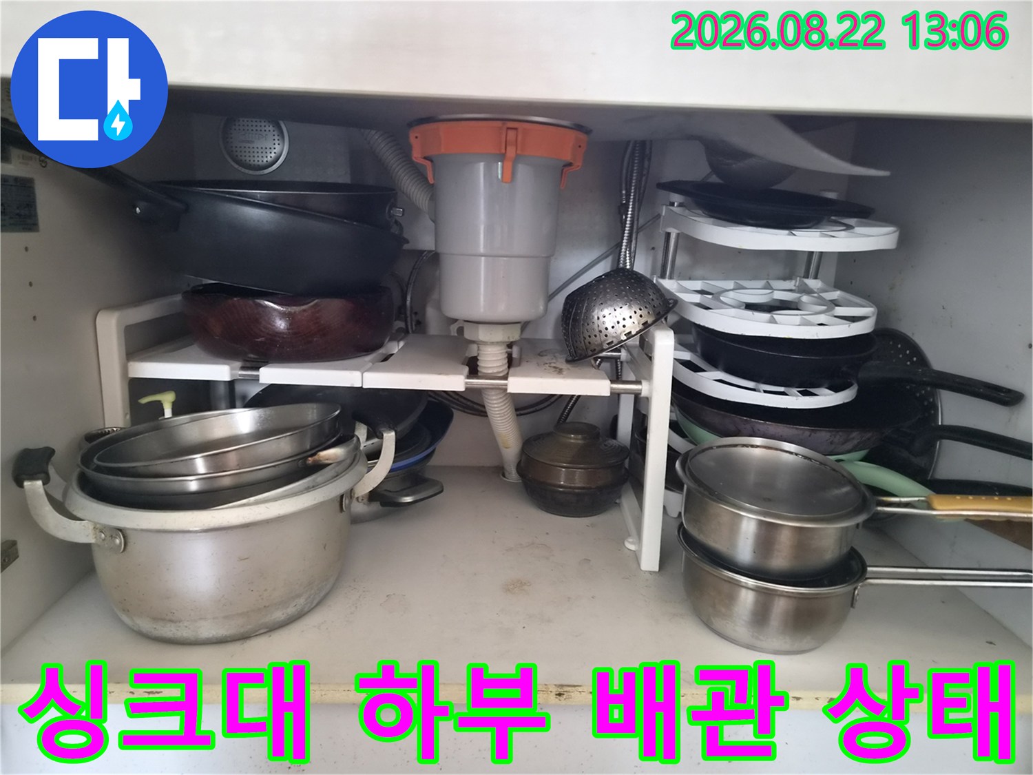 싱크대 하단 배수관-연결 호스와 배수통의 배치 모습
