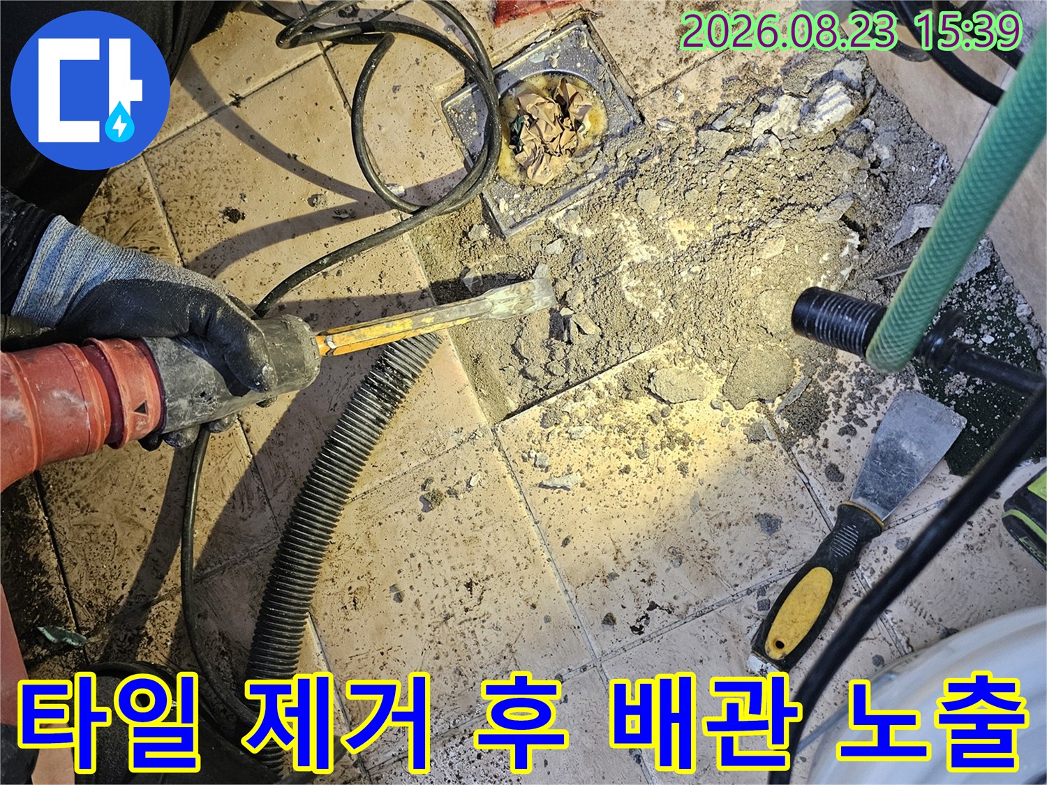 바닥 타일을 깨서 드러난 손상된 매립 배관 부위