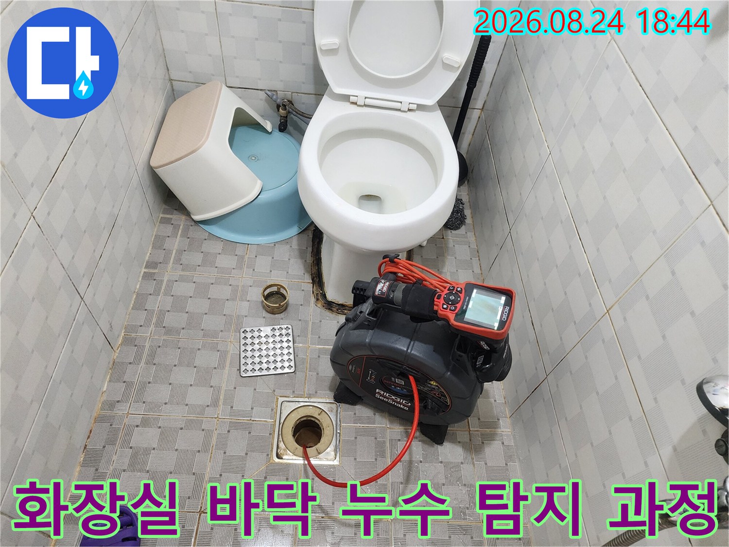 욕실 바닥 하수구 부근에 설치된 배관 점검용 디지털 압력 게이지
