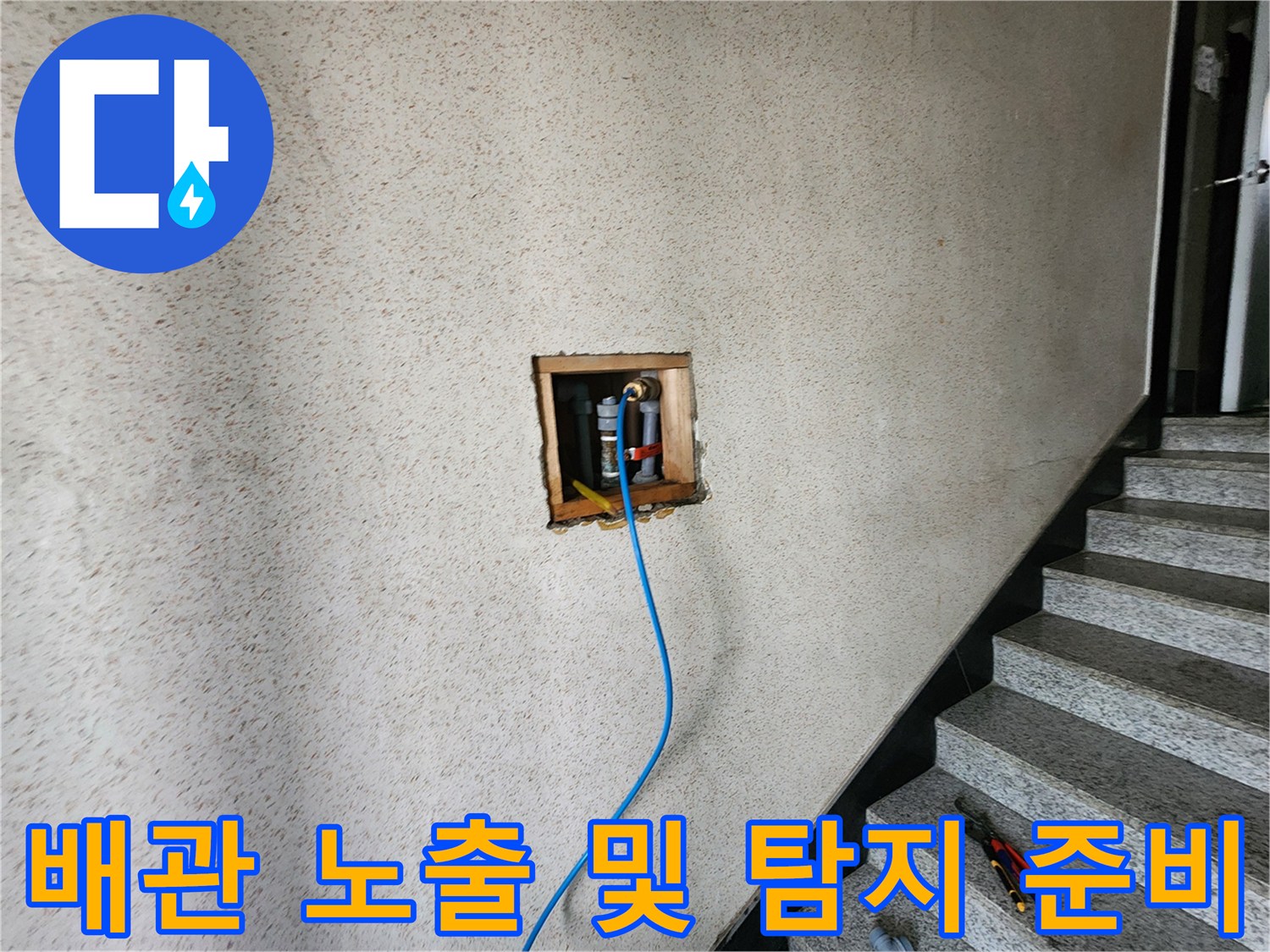 타공된 벽면 내부의 배관과 파란색 공압 테스트 호스