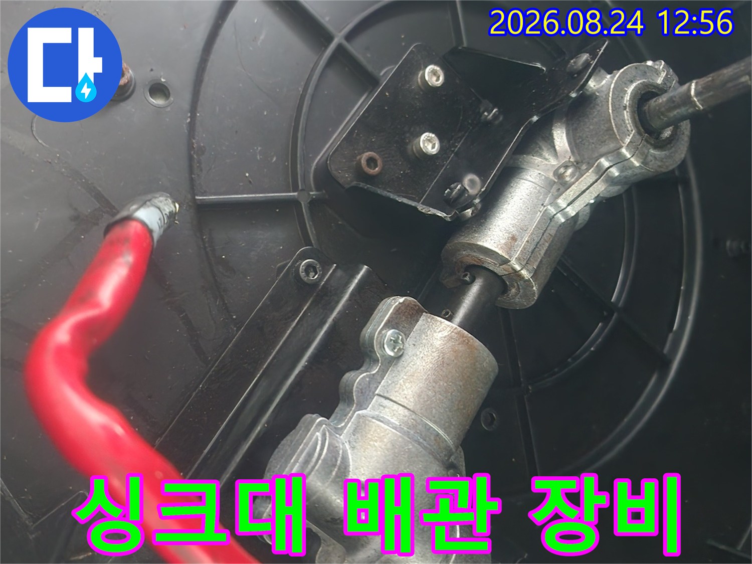 검은색 배관 구조 내부에 설치된 전동 샤프트와 붉은색 호스 연결 부위