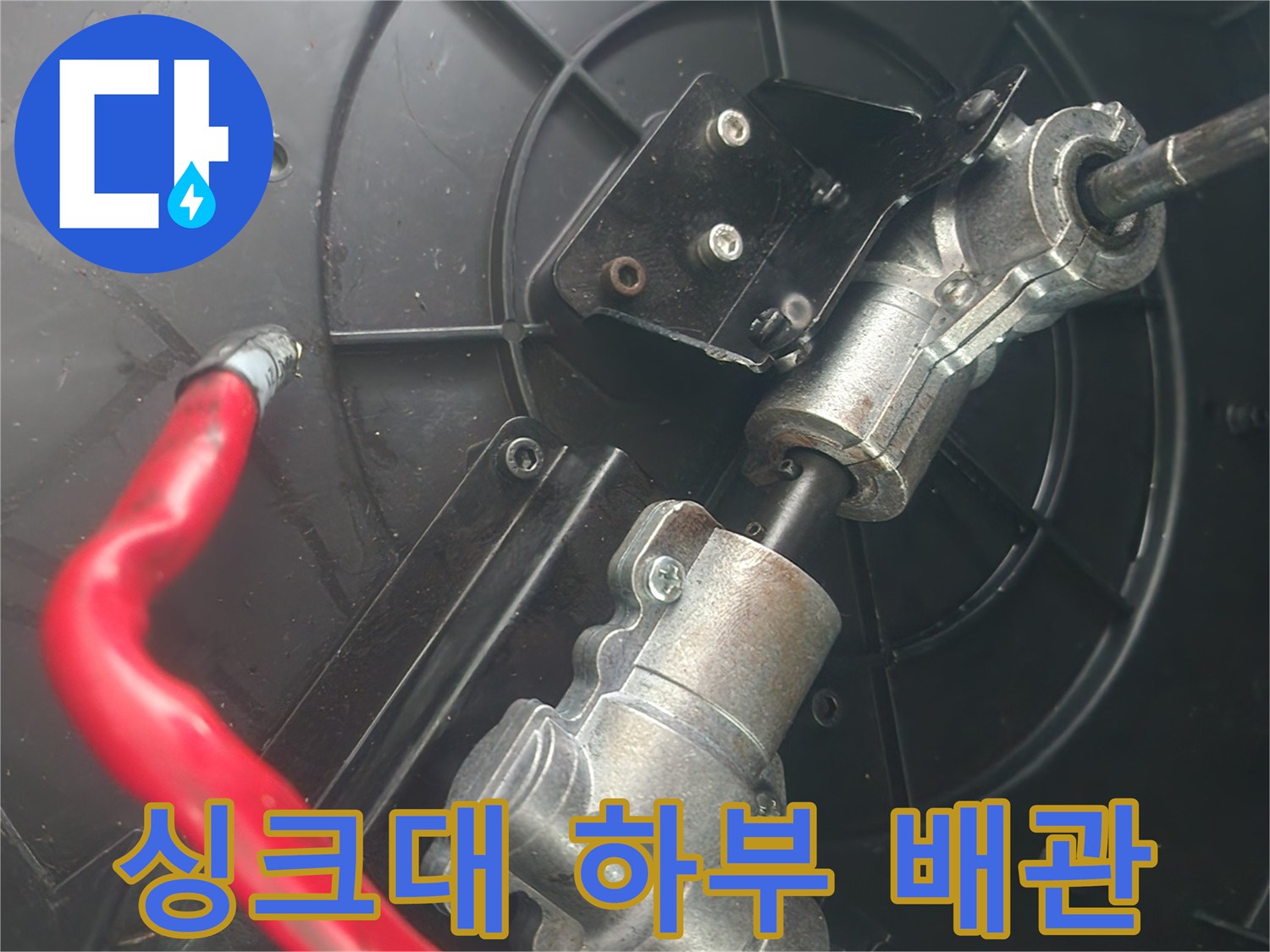 금속 배관 연결 부위와 붉은색 호스가 연결된 모습